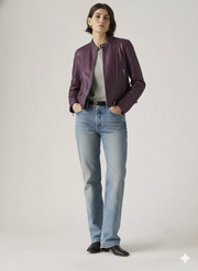 Woman wearing purple leather moto jacket with gray top, blue jeans, and black boots