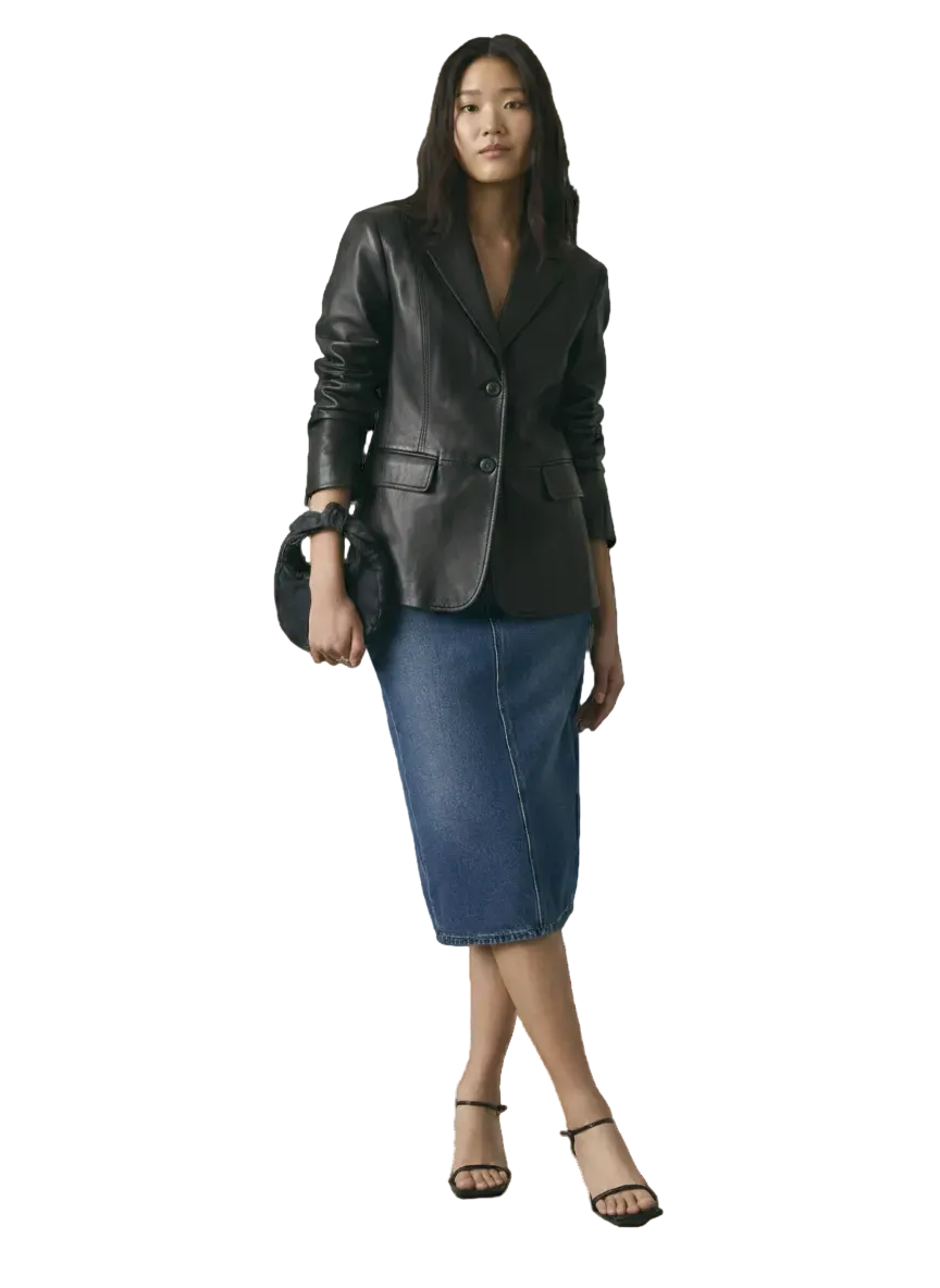 Woman wearing black leather blazer, denim midi skirt, and black heels with a matching handbag.