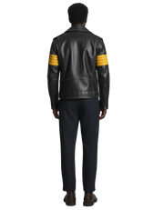 Black leather jacket with yellow striped sleeves, worn with dark pants and brown shoes
