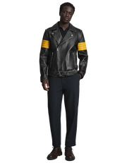 Black leather biker jacket with yellow stripes, paired with dark pants and brown boots