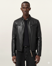 Men's black leather jacket with zipper pockets and stand collar, styled with dark jeans
